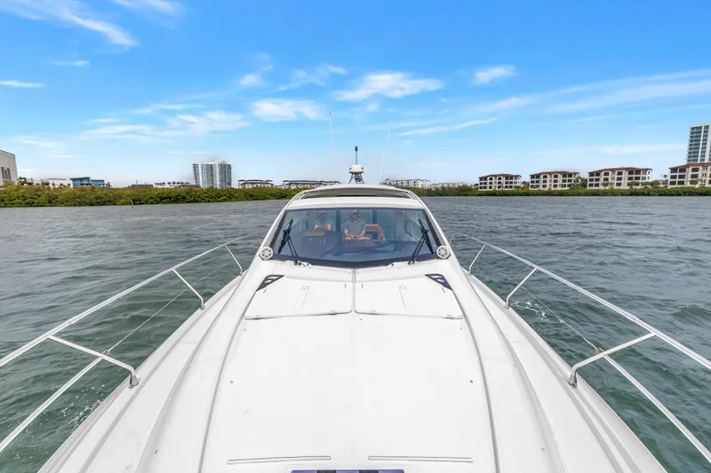 Slide: The Image of 2019 Beneteau Gran Turismo 46 cruising on a scenic waterway with modern buildings in the background. - 24