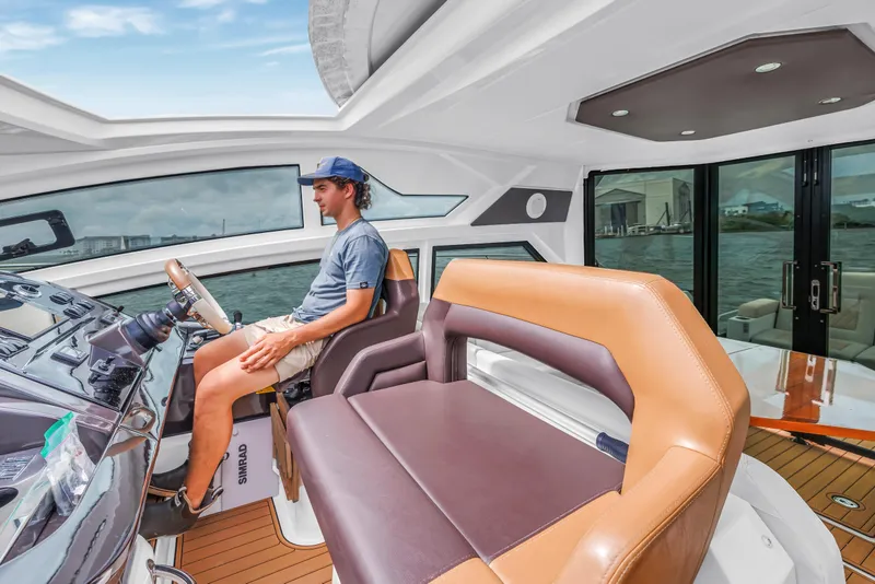 Slide: The Image of Man steering a 2019 Beneteau Gran Turismo 46 yacht on open water. - 35