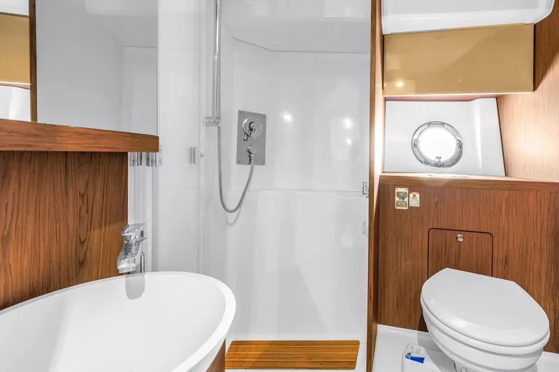 Slide: The Image of Luxurious bathroom in 2019 Beneteau Gran Turismo 46 yacht with modern fixtures and wood accents. - 50