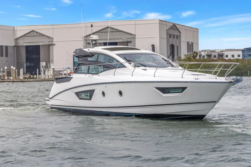 Slide: The Image of 2019 Beneteau Gran Turismo 46 yacht cruising near a marina under a clear sky. - 69
