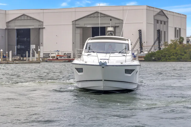 Slide: The Image of 2019 Beneteau Gran Turismo 46 yacht cruising near a marina with industrial buildings. - 72