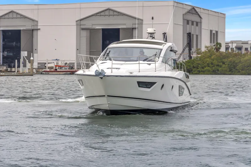 Slide: The Image of 2019 Beneteau Gran Turismo 46 yacht cruising near a marina with industrial buildings. - 74