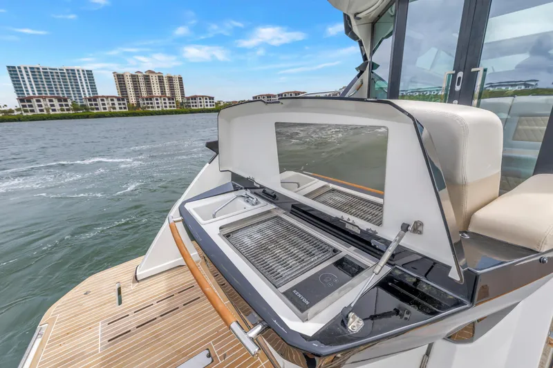 Slide: The Image of 2019 Beneteau Gran Turismo 46 yacht with outdoor grill and scenic waterfront view. - 8
