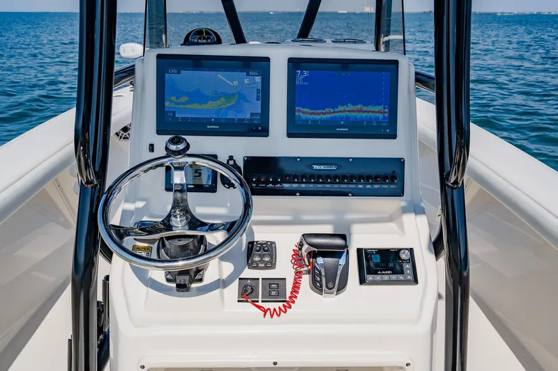 Slide: The Image of 2023 Pathfinder 2700 Open boat dashboard with dual Garmin displays on open water. - 41