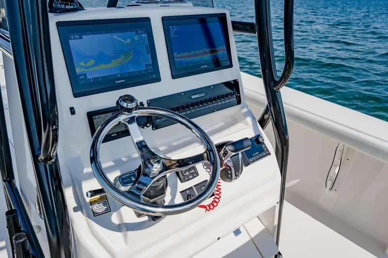 Slide: The Image of 2023 Pathfinder 2700 Open boat dashboard with dual Garmin displays and steering wheel. - 42