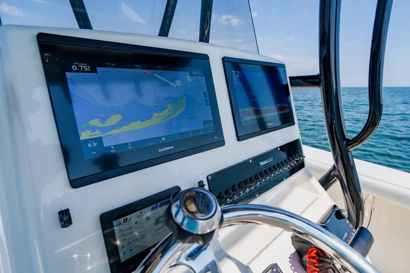 Slide: The Image of 2023 Pathfinder 2700 Open boat dashboard with Garmin navigation screens on open water. - 44