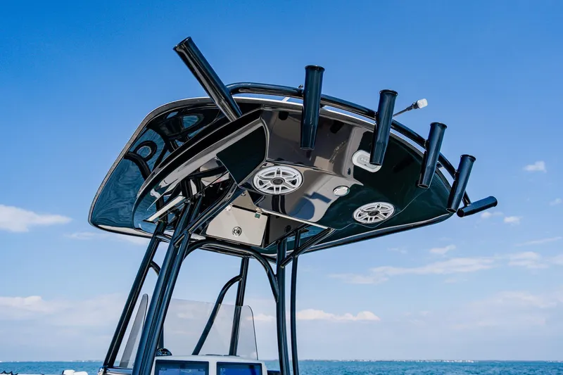 Slide: The Image of 2023 Pathfinder 2700 Open boat's T-top with rod holders and speakers against blue sky. - 49