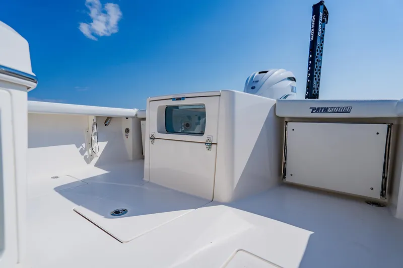 Slide: The Image of 2023 Pathfinder 2700 Open boat deck with storage compartments under a clear blue sky. - 54