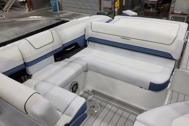 Slide: The Image of 2026 Formula 240 Bowrider interior with white and blue seating in a workshop setting. - 11
