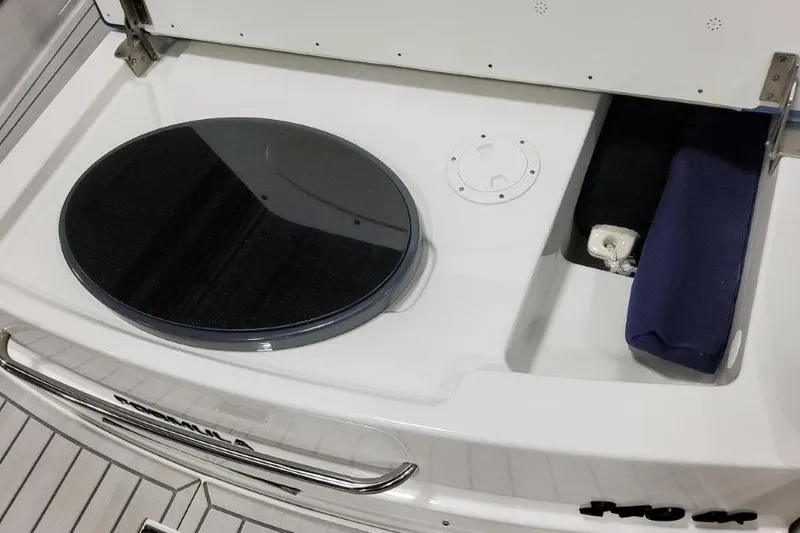 Slide: The Image of 2026 Formula 240 Bowrider boat storage compartment with circular lid and accessories. - 15