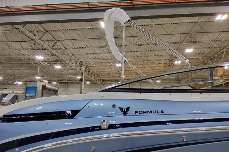 Slide: The Image of 2026 Formula 240 Bowrider boat in a warehouse, showcasing sleek design and modern features. - 2