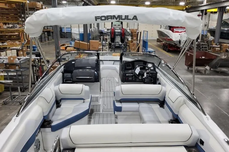 Slide: The Image of 2026 Formula 240 Bowrider boat interior with seating and dashboard in a factory setting. - 6