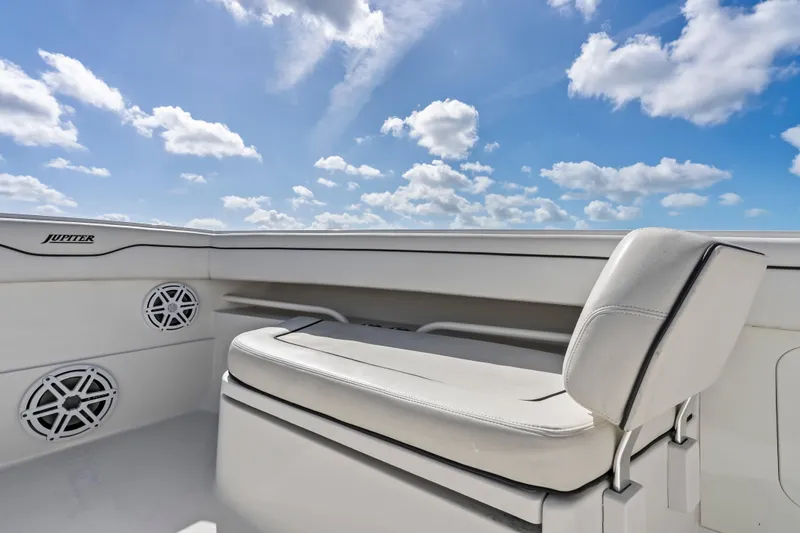 Slide: The Image of 2015 Jupiter 34 HFS boat interior with seating and speakers under a blue sky. - 14