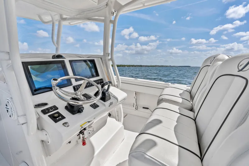 Slide: The Image of 2015 Jupiter 34 HFS boat cockpit with dual screens and plush seating on open water. - 19