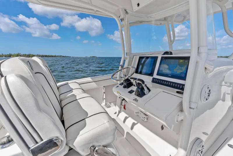 Slide: The Image of 2015 Jupiter 34 HFS boat interior with dual screens and white seating on open water. - 21