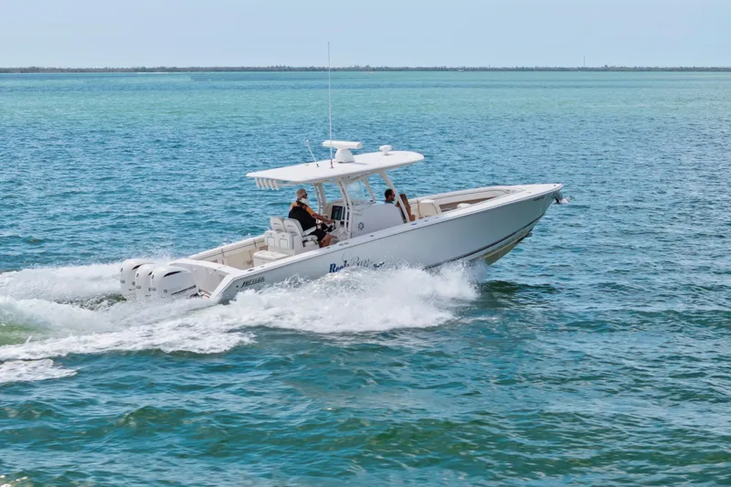 Slide: The Image of 2015 Jupiter 34 HFS boat cruising on open water, showcasing sleek design and powerful engines. - 6