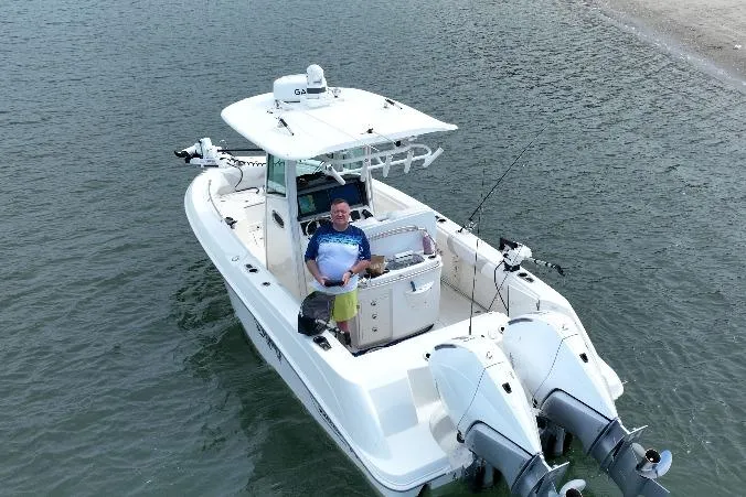 Slide: The Image of 2023 Boston Whaler 250 Outrage boat on water with person at helm. - 6