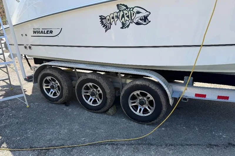 Slide: The Image of 2023 Boston Whaler 250 Outrage on trailer, featuring "Off Grid" graphic. - 8