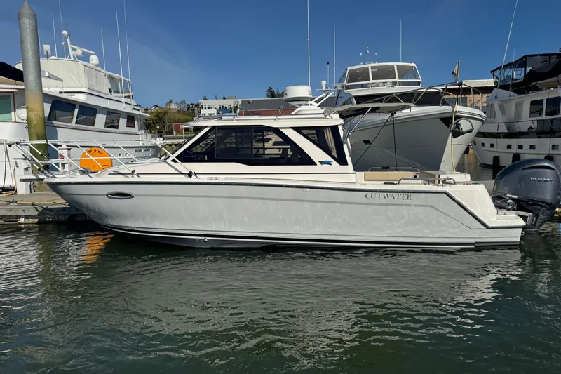 The Image of 2026 Cutwater C-248 Coupe boat docked in marina, surrounded by other vessels. - 0