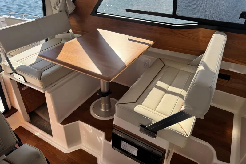 Slide: The Image of Interior of 2026 Cutwater C-248 Coupe featuring a cozy dining area with wooden table. - 11