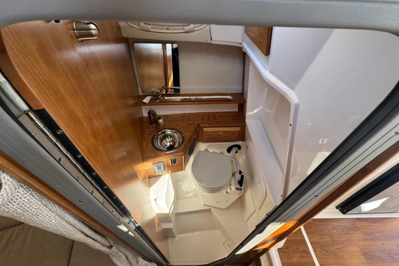 Slide: The Image of 2026 Cutwater C-248 Coupe interior bathroom with wooden accents and compact design. - 13