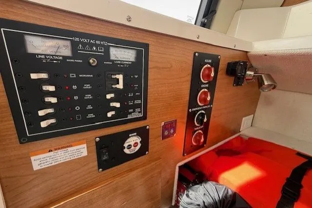 Slide: The Image of Electrical control panel inside 2026 Cutwater C-248 Coupe boat, featuring switches and gauges. - 16