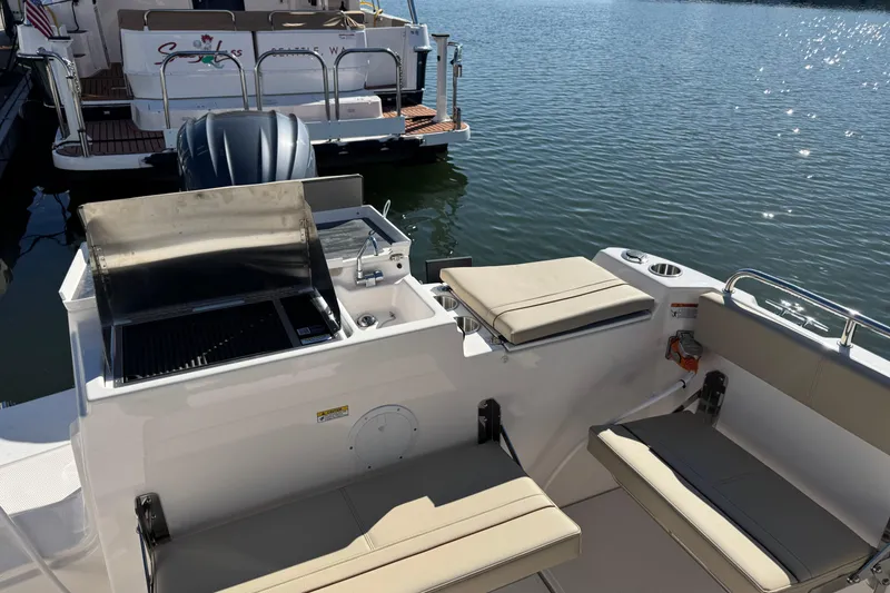 Slide: The Image of 2026 Cutwater C-248 Coupe boat with outdoor grill and seating on calm water. - 6