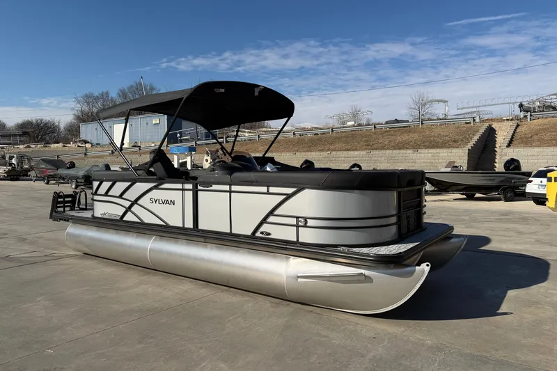 The Image of 2026 Sylvan Mirage X X3 pontoon boat with canopy on a concrete lot. - 0
