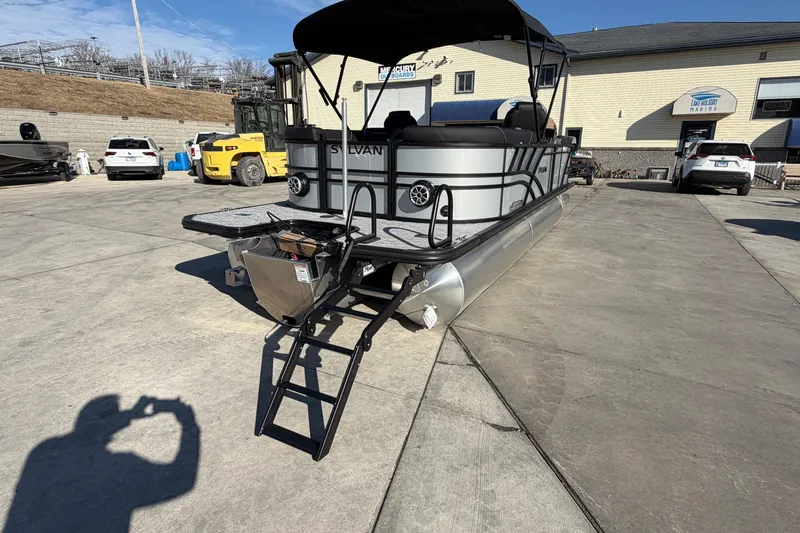 Slide: The Image of 2026 Sylvan Mirage X X3 pontoon boat with ladder, parked in marina lot. - 6
