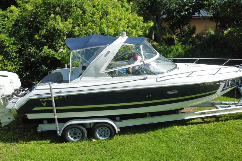 Slide: The Image of 2005 Formula 280 Sun Sport boat on trailer, surrounded by lush greenery. - 12