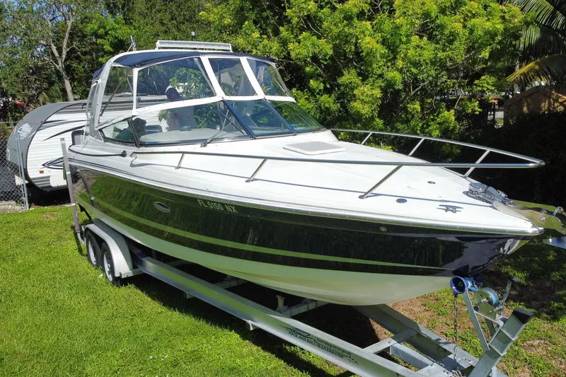 Slide: The Image of 2005 Formula 280 Sun Sport boat on trailer, surrounded by lush greenery. - 13