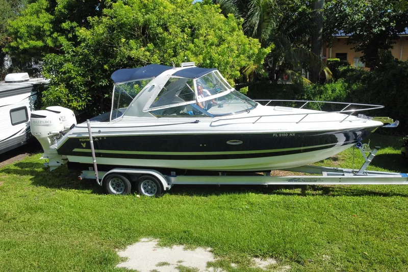 Slide: The Image of 2005 Formula 280 Sun Sport boat on trailer, parked on grass, surrounded by lush greenery. - 14