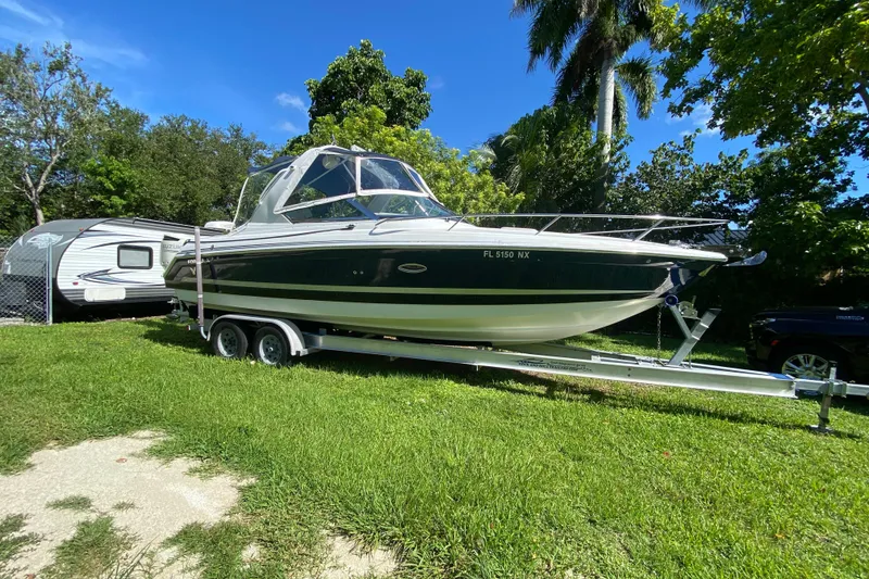 Slide: The Image of 2005 Formula 280 Sun Sport boat on trailer, parked on grass with trees in background. - 3