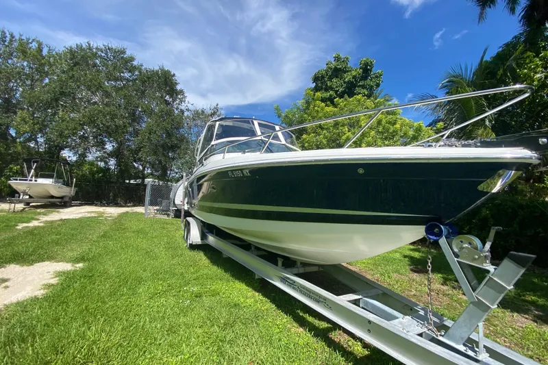 Slide: The Image of 2005 Formula 280 Sun Sport boat on trailer, surrounded by lush greenery. - 5
