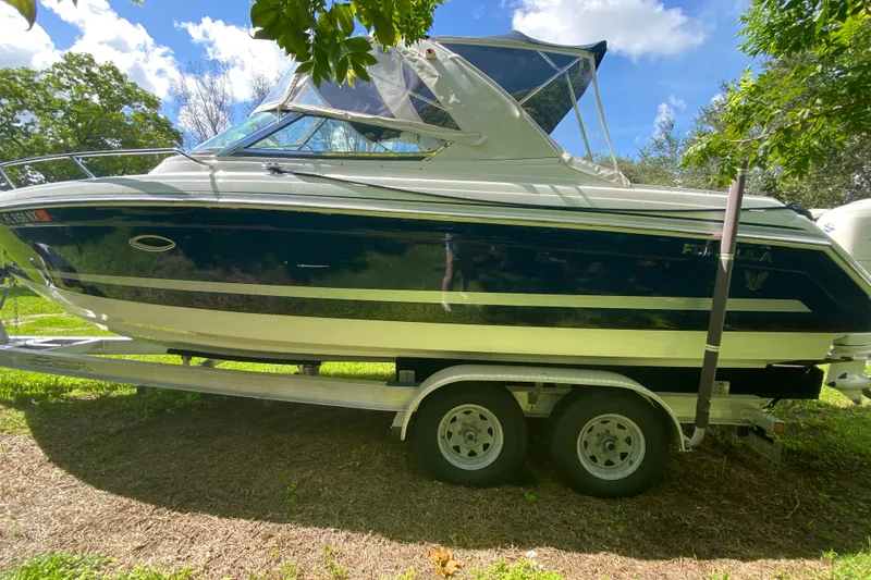 Slide: The Image of 2005 Formula 280 Sun Sport boat on trailer, parked outdoors under blue sky. - 8