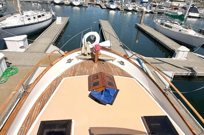 Slide: The Image of 1978 Marine Trader Europa yacht docked at marina, showcasing wooden deck and nautical equipment. - 10