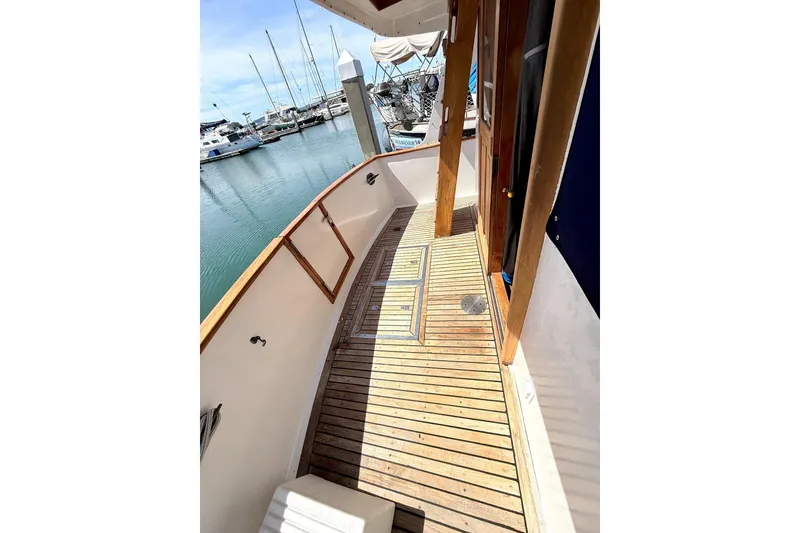 Slide: The Image of 1978 Marine Trader Europa yacht deck with wooden flooring, docked at a marina. - 11