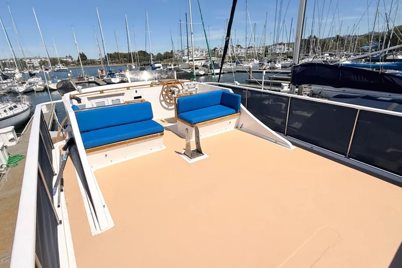 Slide: The Image of 1978 Marine Trader Europa yacht deck with blue seating, docked at a marina. - 12