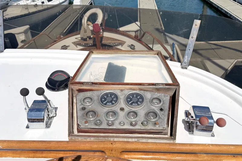 Slide: The Image of 1978 Marine Trader Europa boat dashboard with gauges and controls at a marina. - 14