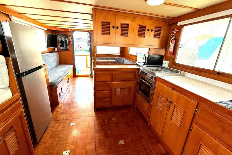 Slide: The Image of Interior of a 1978 Marine Trader Europa boat with wooden cabinetry and modern appliances. - 17