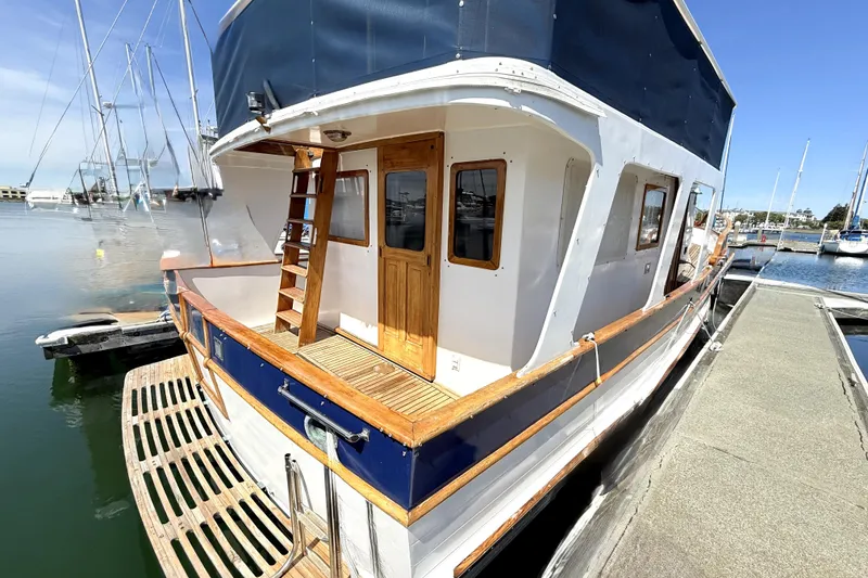 Slide: The Image of 1978 Marine Trader Europa yacht docked, showcasing wooden accents and nautical design. - 2