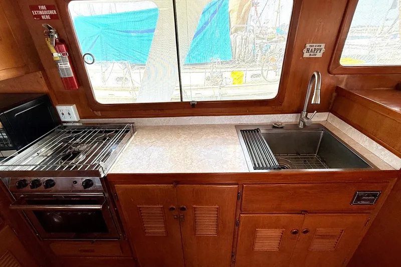 Slide: The Image of 1978 Marine Trader Europa kitchen with stove, sink, and wooden cabinetry. - 20