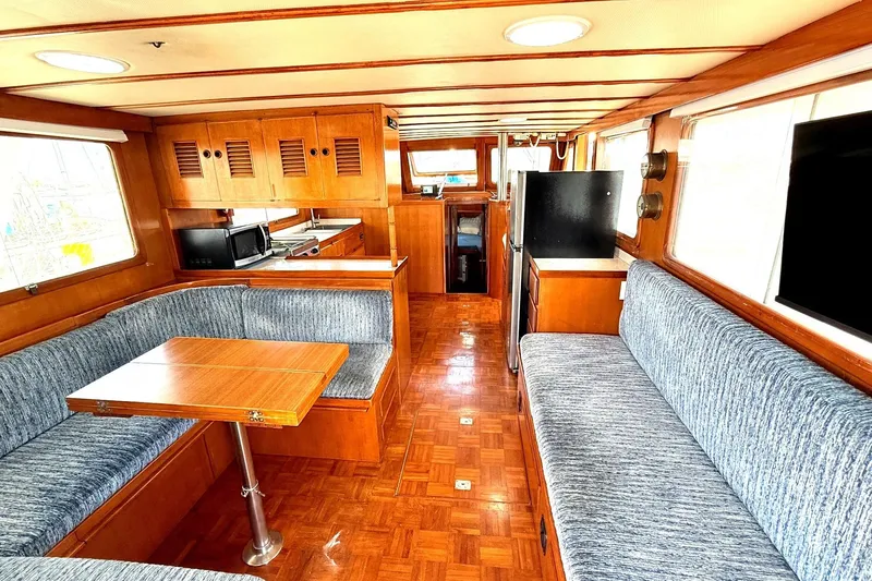 Slide: The Image of 1978 Marine Trader Europa yacht interior with wood finishes and blue upholstered seating. - 21