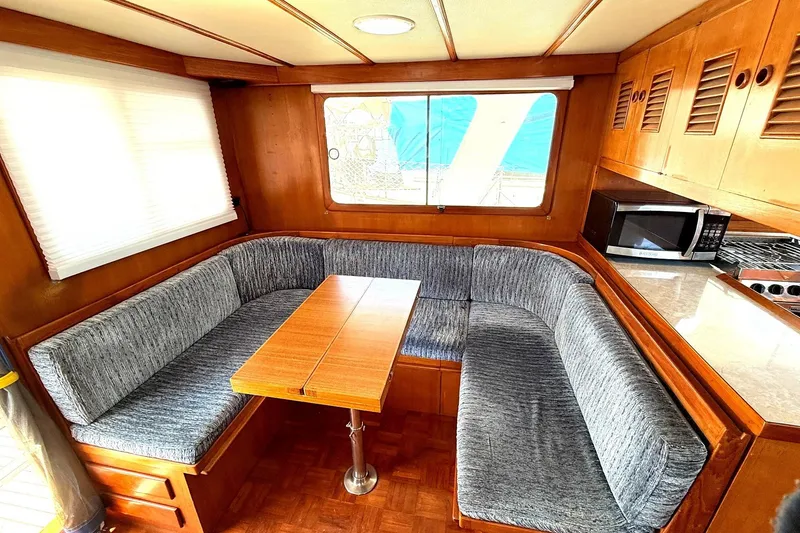 Slide: The Image of 1978 Marine Trader Europa interior with cozy dining area, wooden table, and built-in seating. - 22