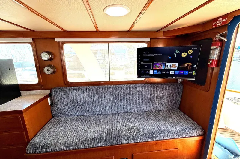 Slide: The Image of 1978 Marine Trader Europa interior with sofa, mounted TV, and nautical decor. - 23