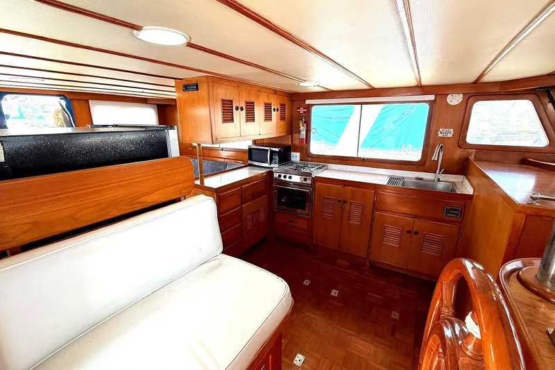 Slide: The Image of 1978 Marine Trader Europa yacht interior with wooden cabinetry and kitchen amenities. - 24