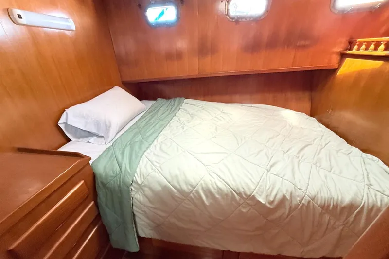 Slide: The Image of Cozy cabin bedroom in 1978 Marine Trader Europa yacht with wooden walls and bedding. - 26