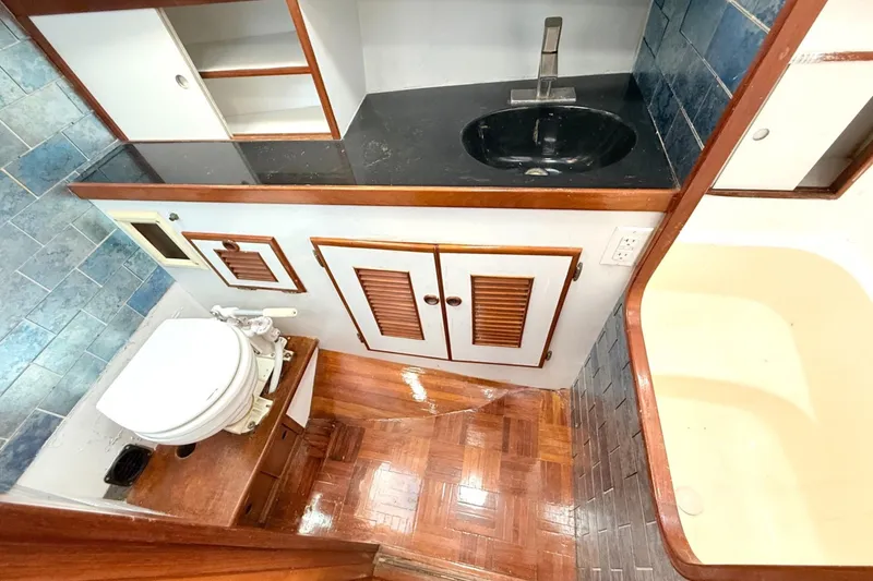 Slide: The Image of 1978 Marine Trader Europa bathroom with wooden cabinetry, sink, and toilet. - 29