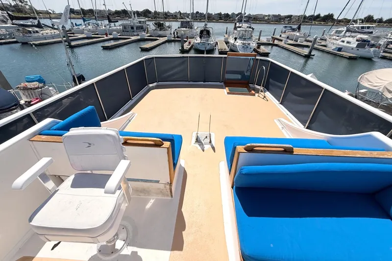 Slide: The Image of 1978 Marine Trader Europa yacht deck with blue seating, overlooking marina. - 8