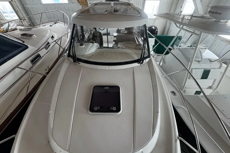 Slide: The Image of 2016 Jeanneau Merry Fisher 855 boat docked indoors, showcasing sleek design and spacious deck. - 10